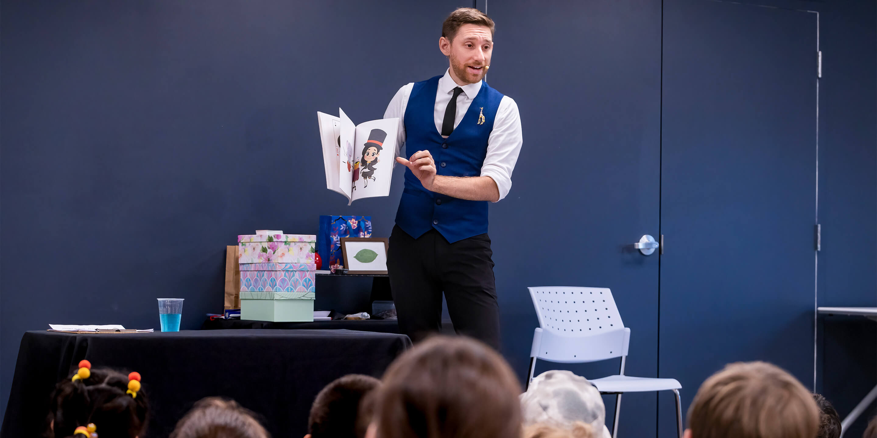 Group of children watching intently as Vincenzo performs at the Library.